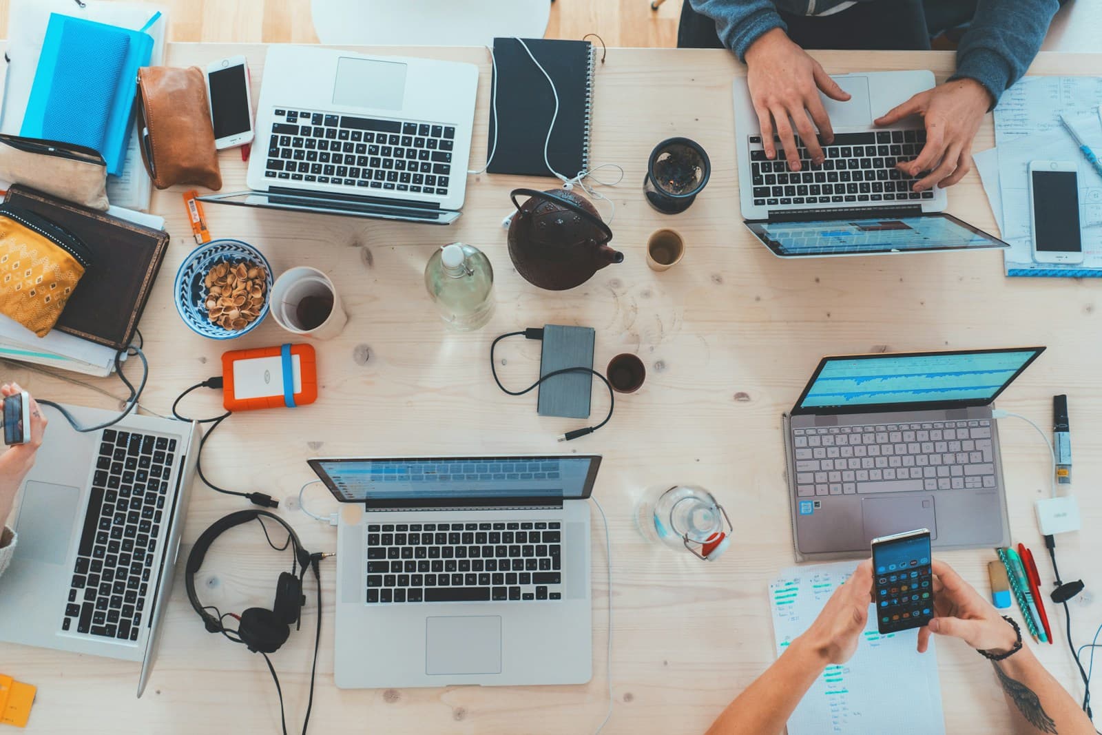 Equipo de trabajo reunido alrededor de una mesa con computadoras